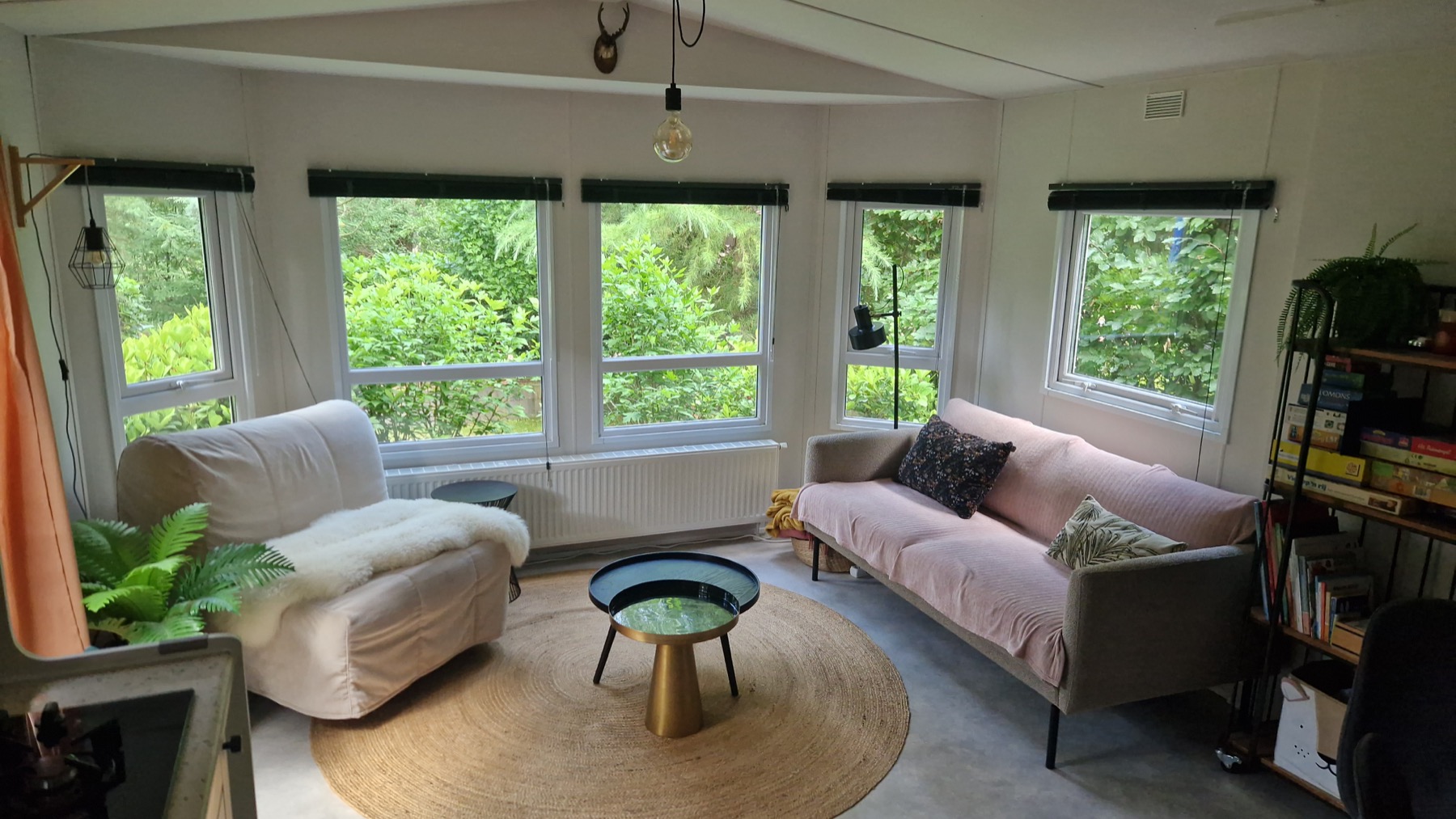 Knusse zithoek van natuurhuisje De Pimpelmees in Ermelo met uitzicht op groen