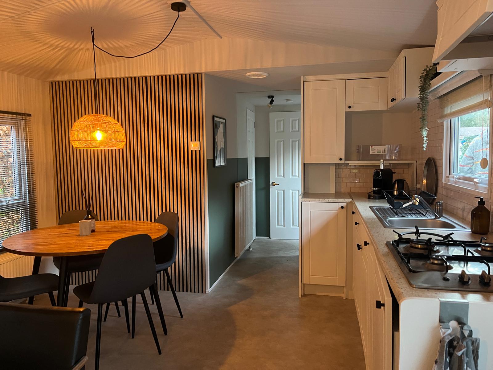 Eethoek en keuken van het natuurhuisje in warm avondlicht
